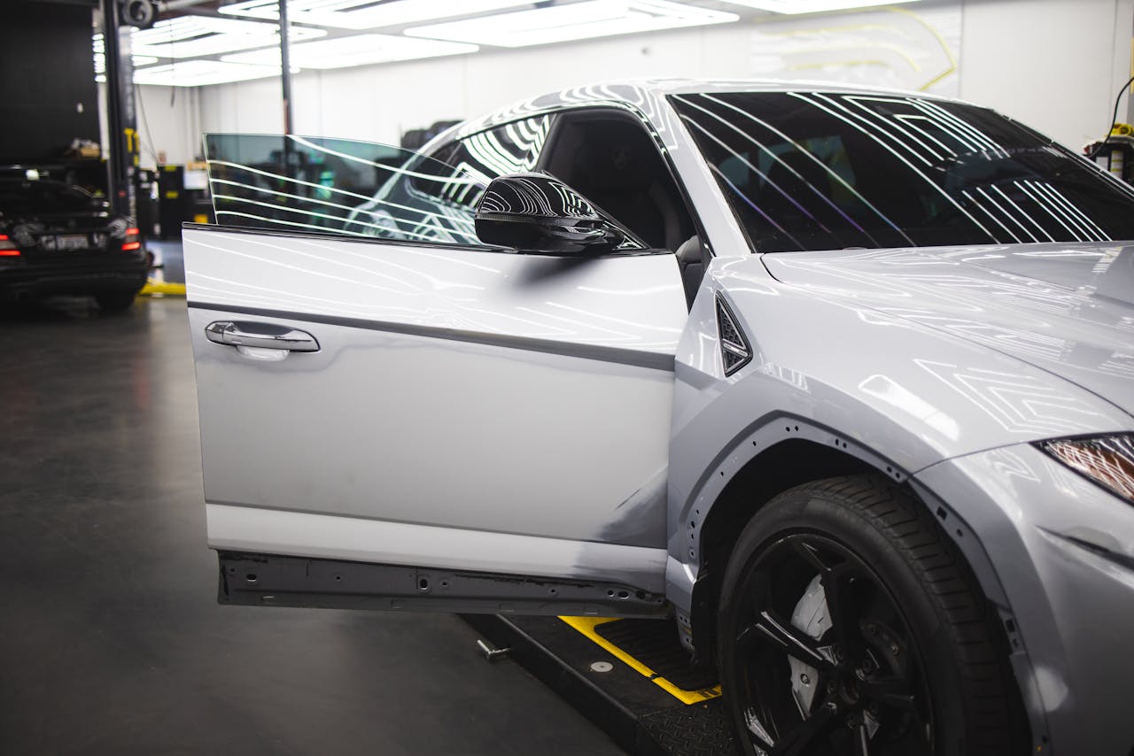 Services Luxury vehicle undergoing service in a well-lit auto repair shop, showcasing sleek design and glossy finish.